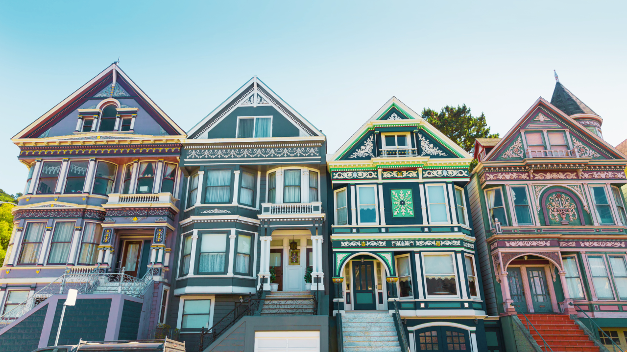 An architectural ensemble of Victorian houses in San Francisco, exhibiting a range of decorative details, vibrant colors, and historical design elements typical of the city's famous Painted Ladies.