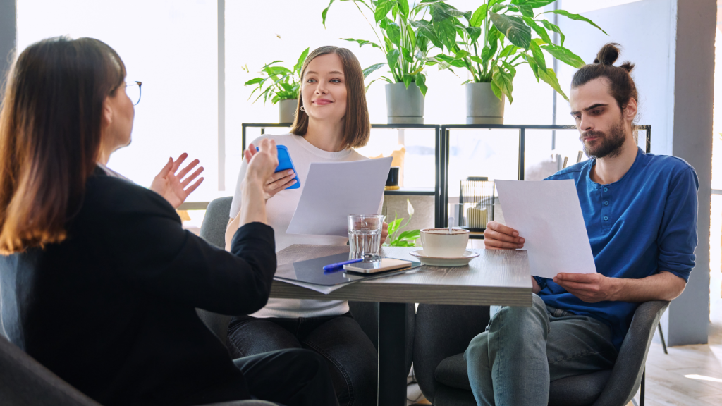 Couple of young clients at meeting with a mortgage lender in an office setting